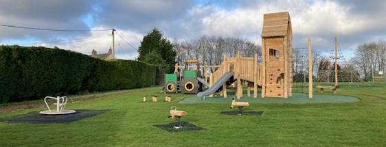 A playground with a slide and a wooden structure

Description automatically generated