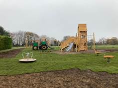 A playground with a slide and a tractor

Description automatically generated