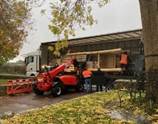 A truck loading a wood into a building

Description automatically generated