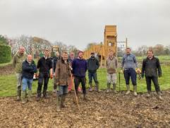 A group of men standing in a field

Description automatically generated